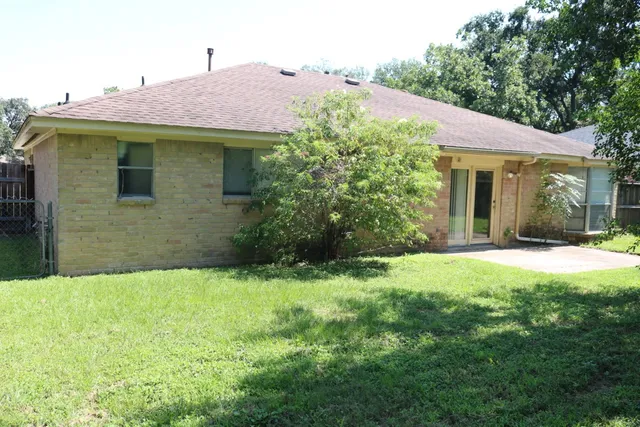 a view of a house with a yard and potted plants