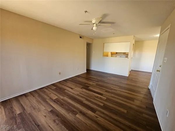 a view of a room with wooden floor and ceiling fan