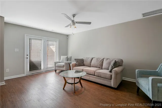 a living room with furniture and a wooden floor