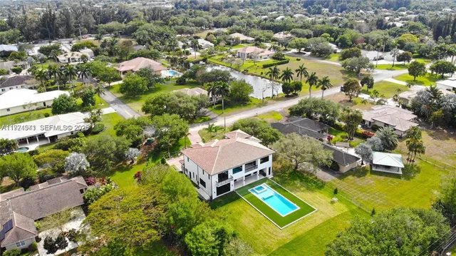 an aerial view of a house with a garden and swimming pool