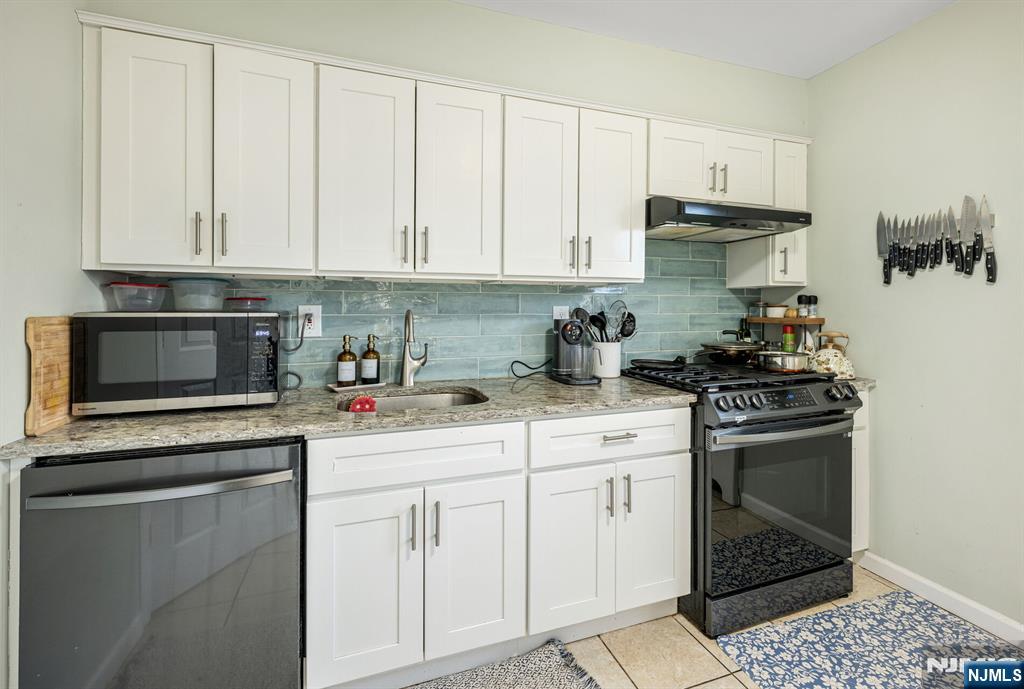 16-08 Plaza Road, Unit B Fair Lawn, NJ 07410 - Photo 12 of 16 a kitchen with white cabinets and appliances