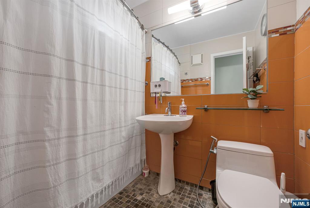 16-08 Plaza Road, Unit B Fair Lawn, NJ 07410 - Photo 16 of 16 a bathroom with a sink a toilet and shower