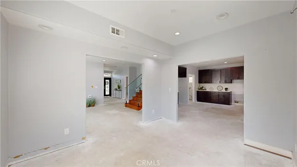 a kitchen with granite countertop a refrigerator sink stove and cabinets