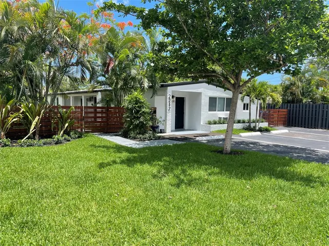 a front view of a house with a yard and trees