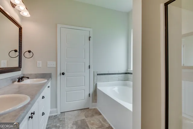 a bathroom with a tub sink and mirror