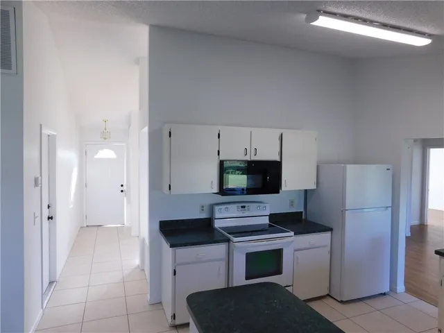 a kitchen with a refrigerator and a stove top oven