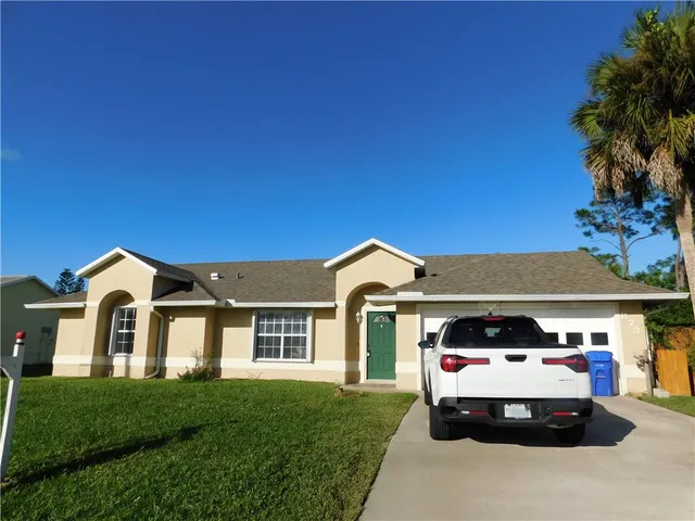 a car parked in front of a white house