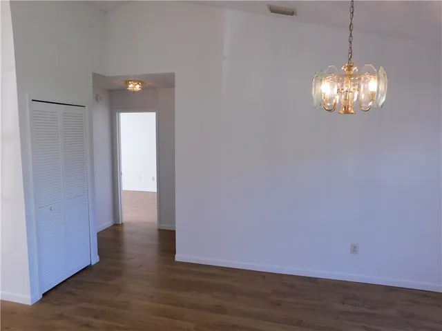 a view of a room with wooden floor and chandelier