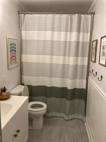 a bathroom with a sink a toilet a mirror and shower curtain