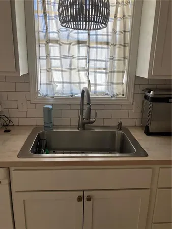 a kitchen with a sink a window and cabinets