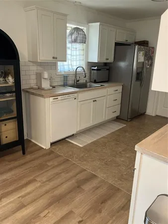 a kitchen with stainless steel appliances a sink a refrigerator and wooden cabinets