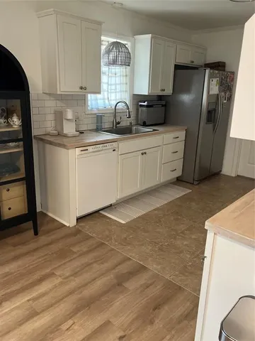 a kitchen with stainless steel appliances a sink a refrigerator and wooden cabinets