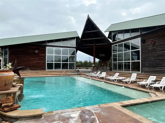 a view of a house with backyard sitting area and pool