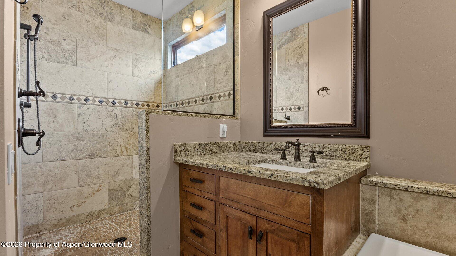 829 Ute Circle New Castle, CO 81647 - Photo 18 of 37 a bathroom with a granite countertop sink and a mirror