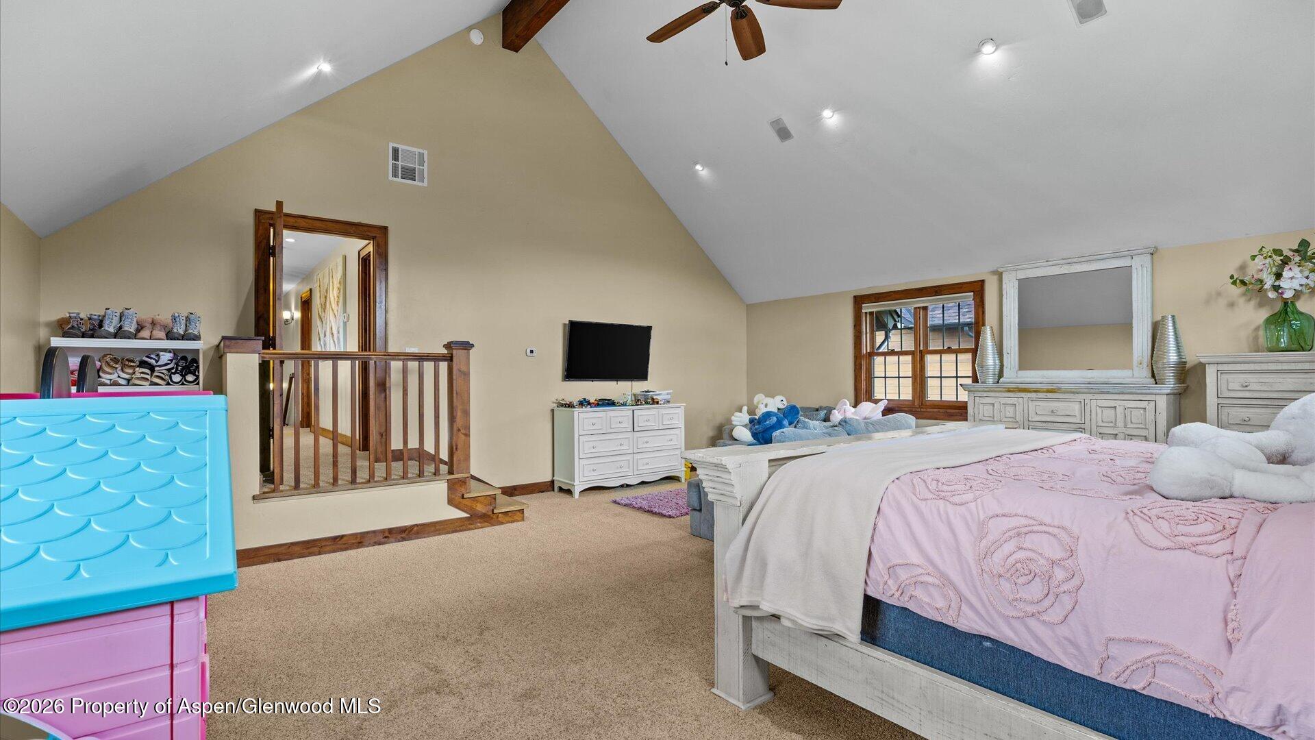 829 Ute Circle New Castle, CO 81647 - Photo 21 of 37 a spacious bedroom with a bed a dresser and floor to ceiling window
