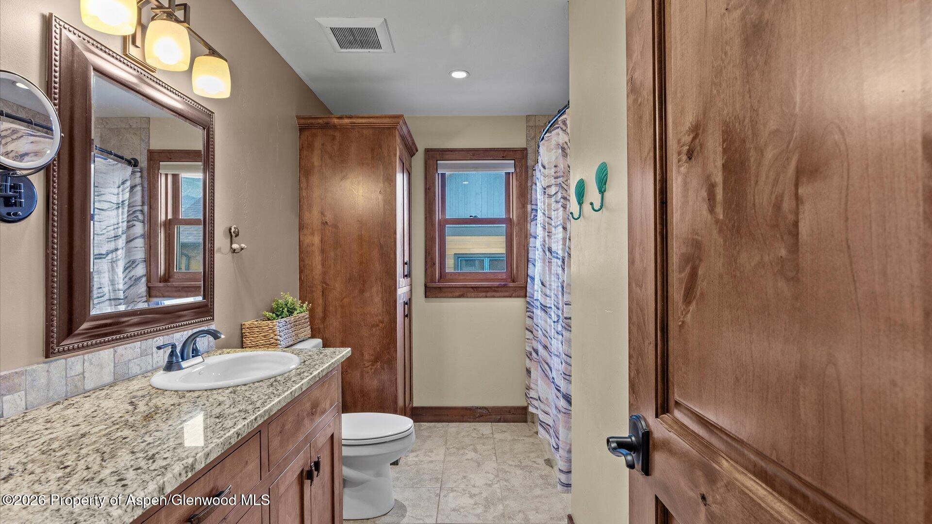 829 Ute Circle New Castle, CO 81647 - Photo 26 of 37 a bathroom with a granite countertop sink and a mirror