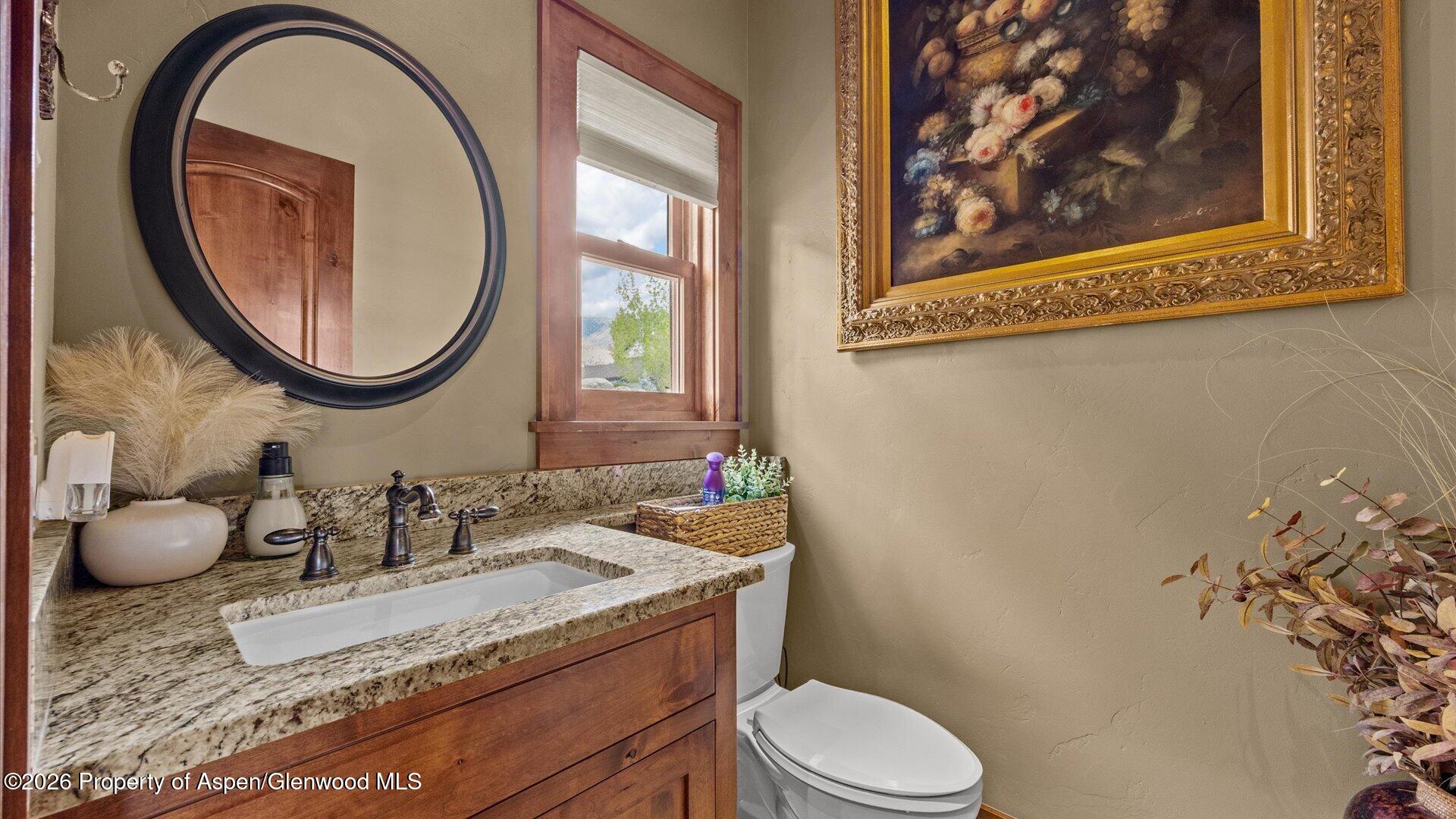 829 Ute Circle New Castle, CO 81647 - Photo 27 of 37 a bathroom with a granite countertop toilet sink and mirror