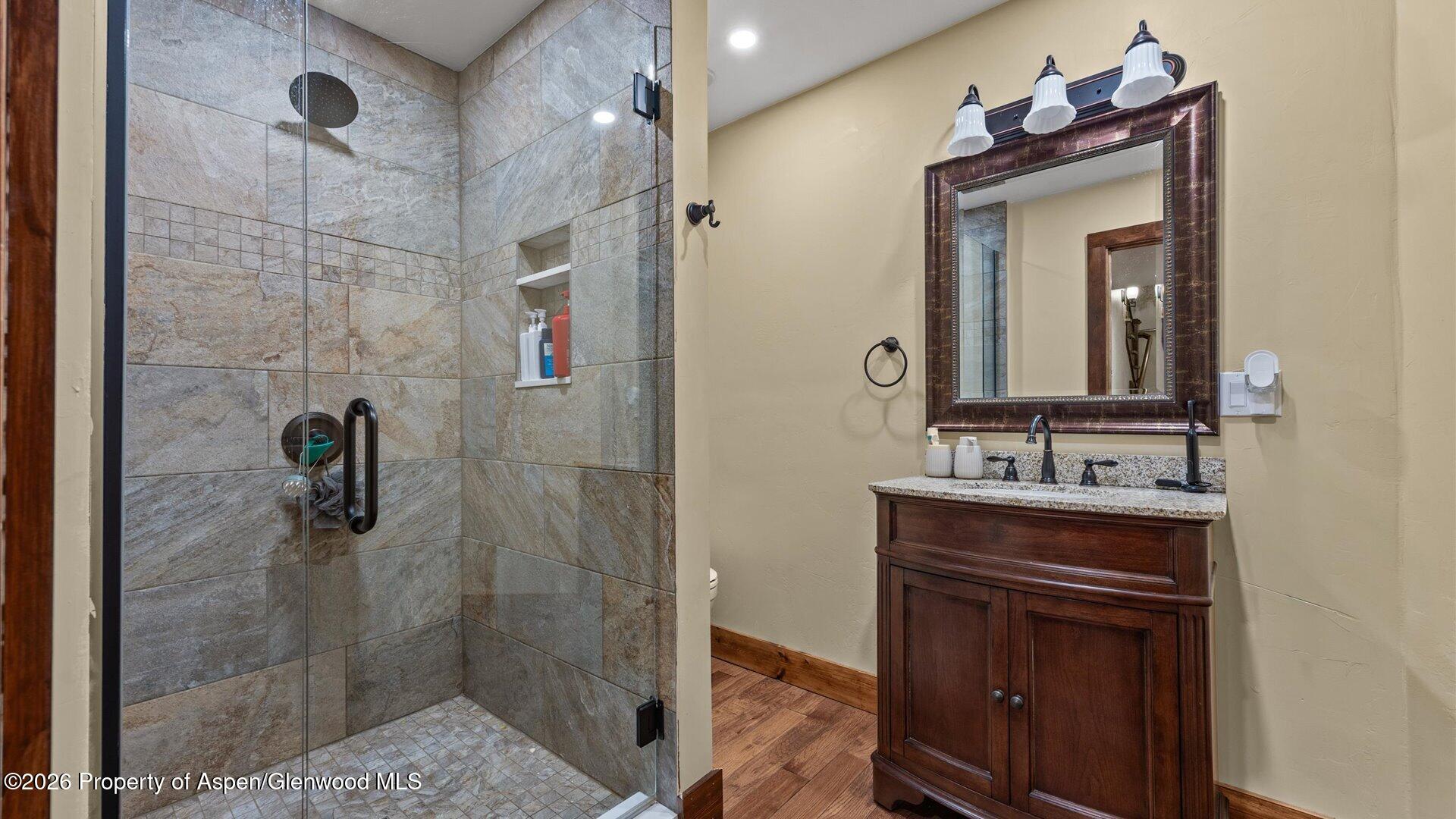 829 Ute Circle New Castle, CO 81647 - Photo 30 of 37 a bathroom with a granite countertop sink a mirror and shower