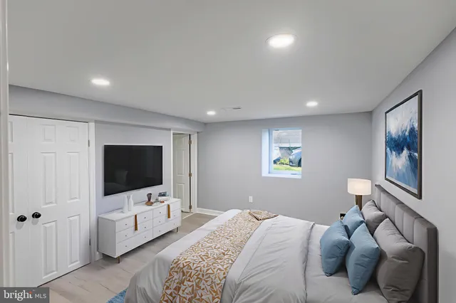 a bedroom with a bed and a flat tv screen on dresser