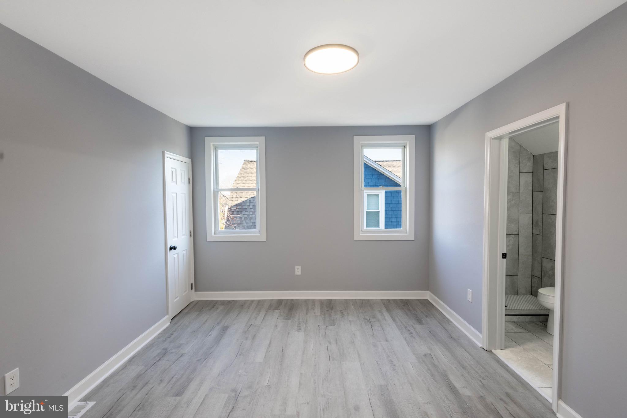 619 Aldershot Road Baltimore, MD 21229 - Photo 20 of 29 wooden floor in an empty room with a window