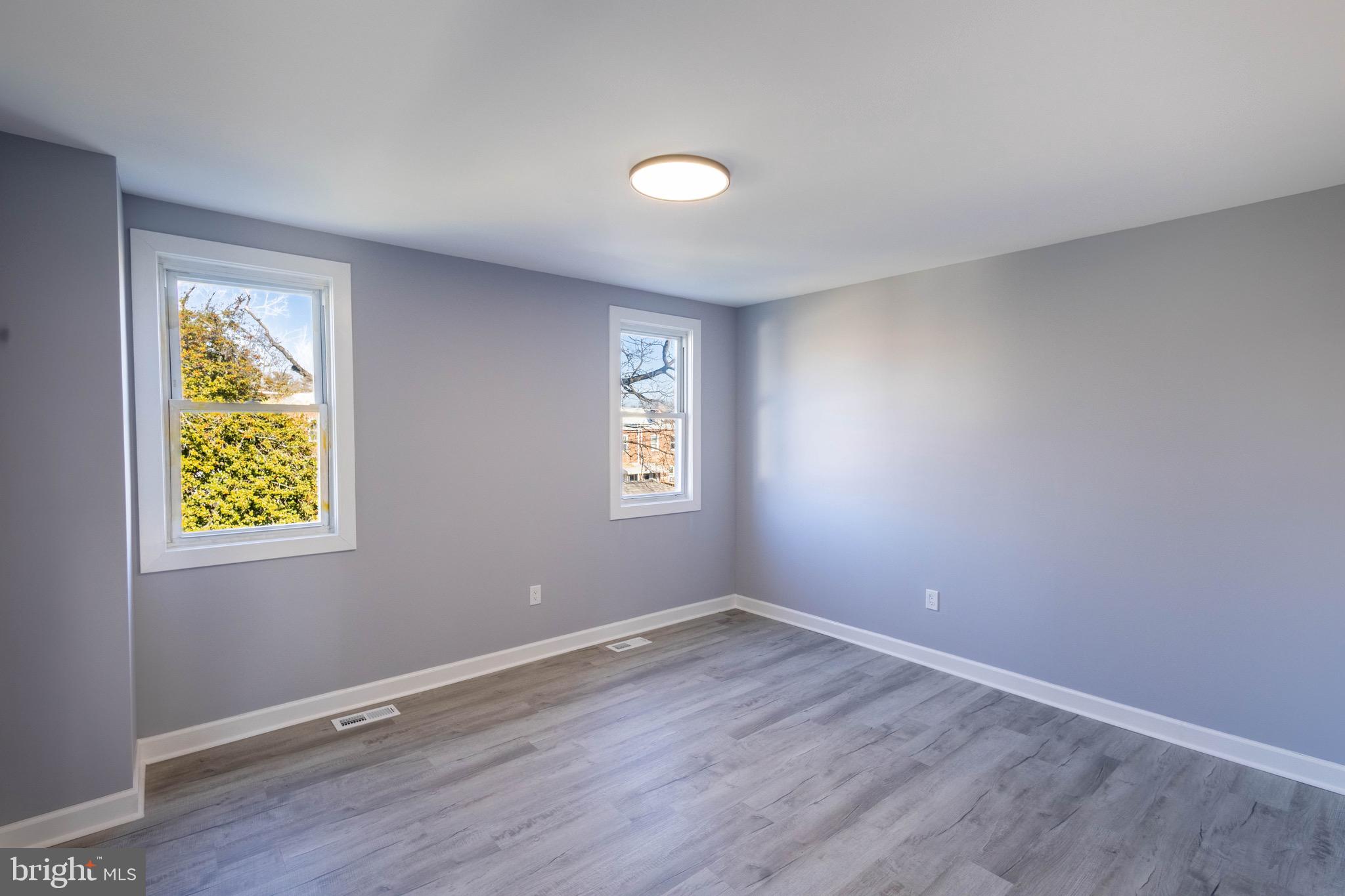 619 Aldershot Road Baltimore, MD 21229 - Photo 22 of 29 a view of an empty room with window and wooden floor