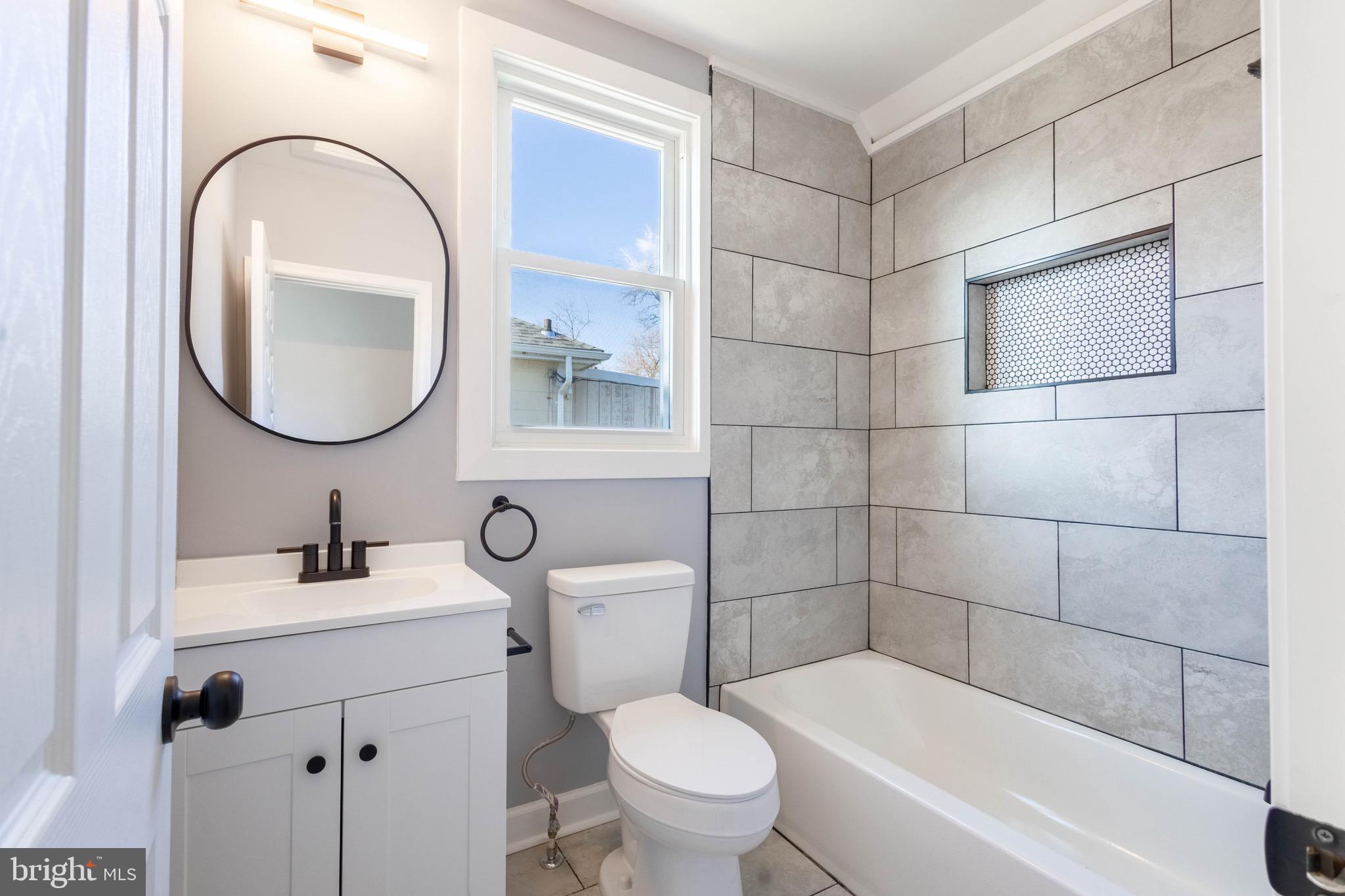 619 Aldershot Road Baltimore, MD 21229 - Photo 26 of 29 a bathroom with a toilet sink and mirror