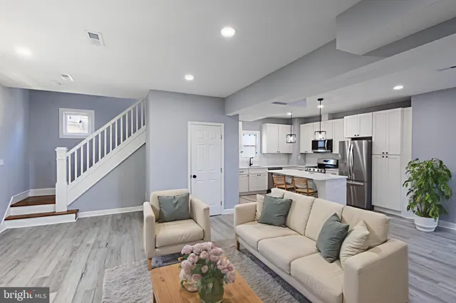 a living room with stainless steel appliances furniture and a view of kitchen