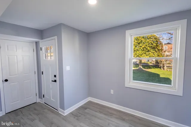 a view of an empty room with window and closet area