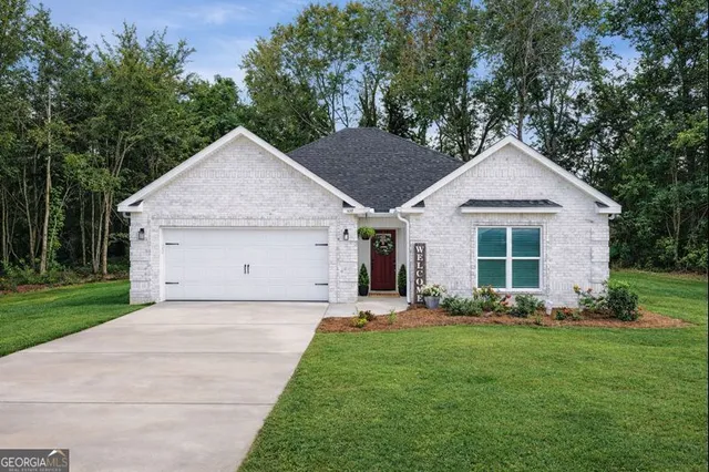 a view of a house with a yard potted plants and a large tree
