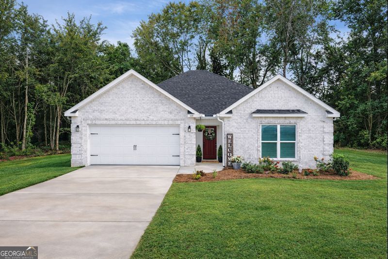 a view of a house with a yard potted plants and a large tree