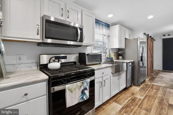 a kitchen with stainless steel appliances a stove microwave and sink