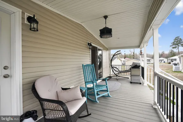 a balcony with view of a couch and chairs