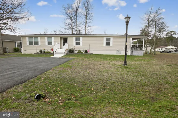 a view of a yard in front of a house with a large tree
