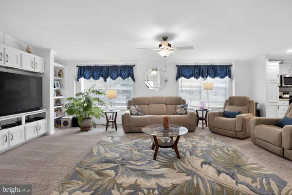 a living room with furniture a chandelier and a flat screen tv