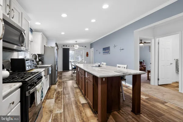 a kitchen with stainless steel appliances a sink a stove top oven a counter space and cabinets