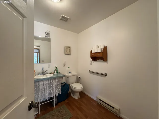 a bathroom with a toilet a sink and mirror