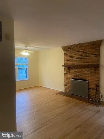 a view of empty room with wooden floor and fireplace