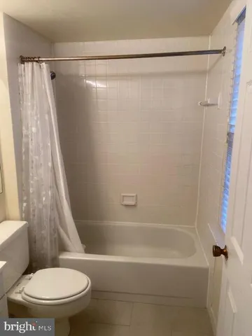 a white toilet sitting next to a bath tub