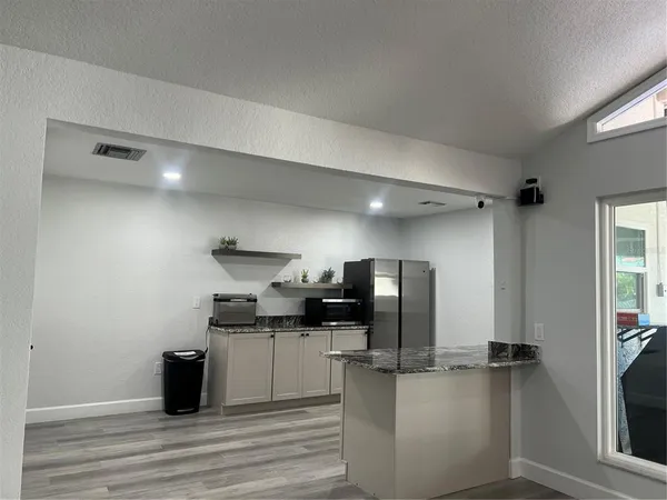 a kitchen with stainless steel appliances kitchen island granite countertop a refrigerator and a stove