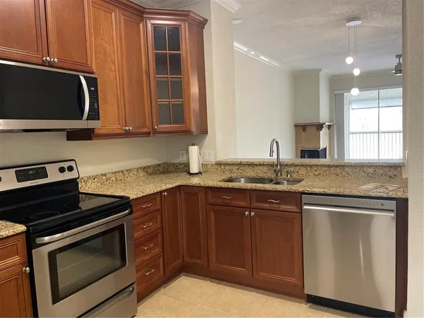 a kitchen with stainless steel appliances granite countertop a stove microwave and sink
