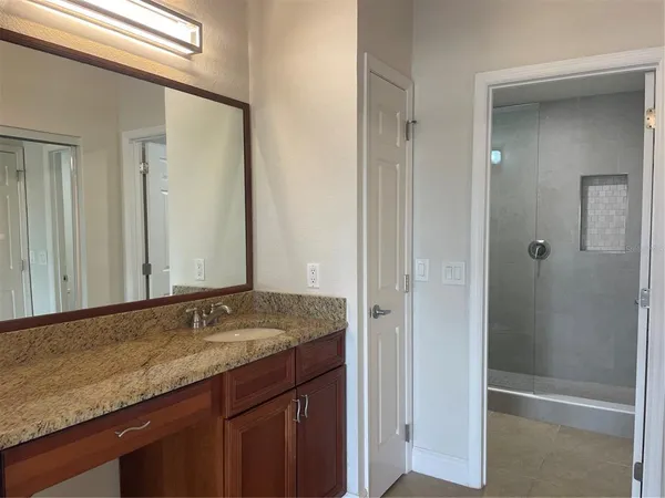 a bathroom with a granite countertop sink and a mirror