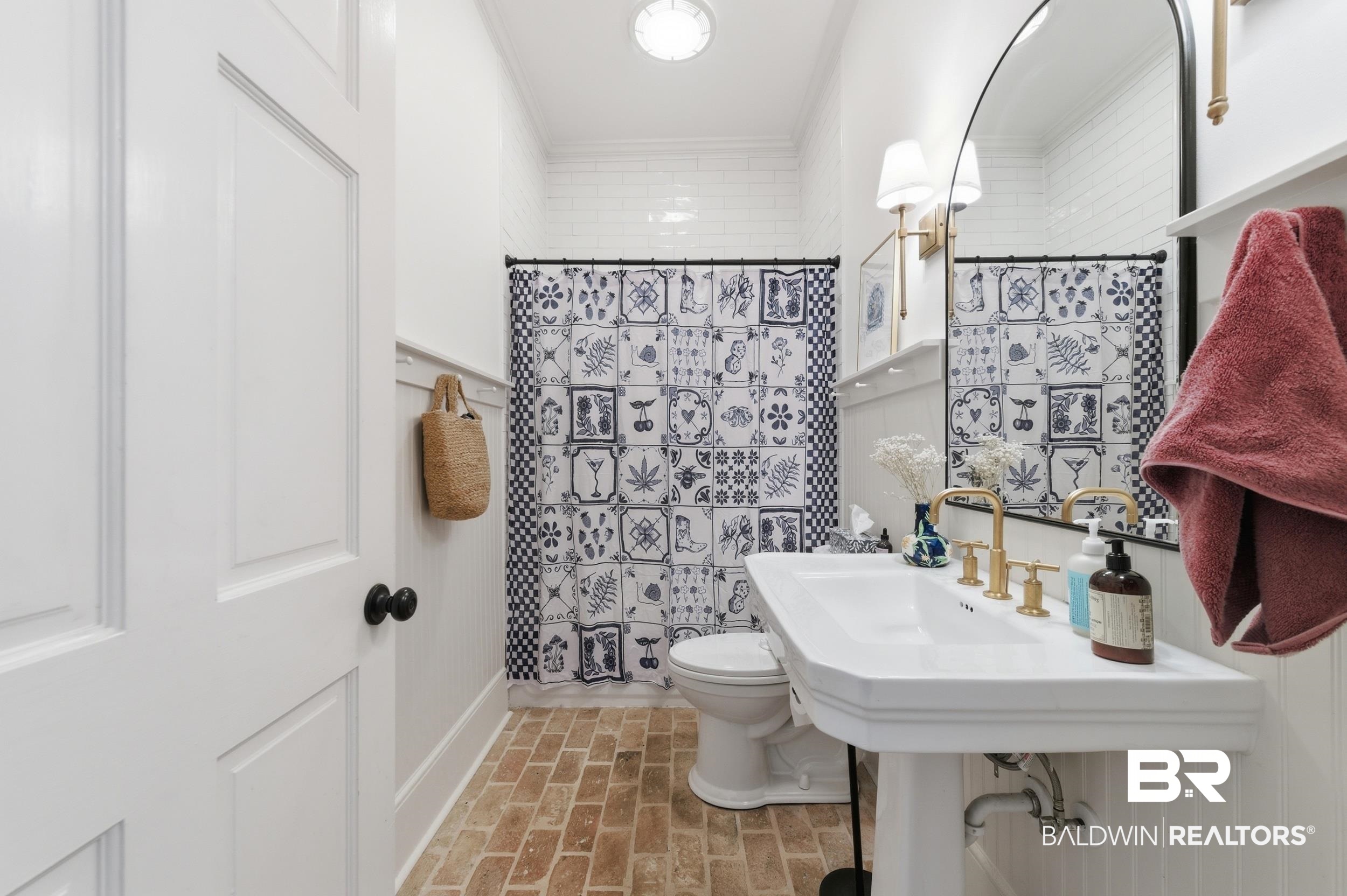 350 Charles Street Mobile, AL 36604 - Photo 27 of 52 Bathroom featuring a pedestal sink with brass-finish fixtures, a large mirror, and white subway tile shower surround