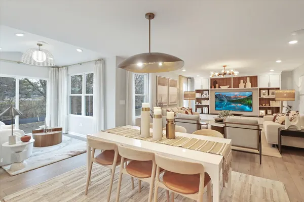 a dining room with stainless steel appliances kitchen island granite countertop a dining table chairs and a living room view