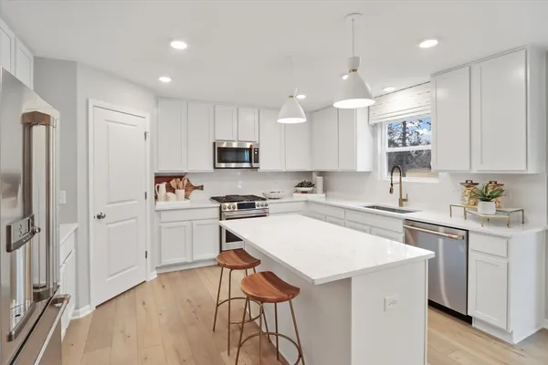 a kitchen with a refrigerator a sink and cabinets
