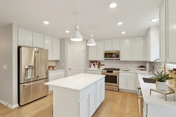 a kitchen with white cabinets and stainless steel appliances