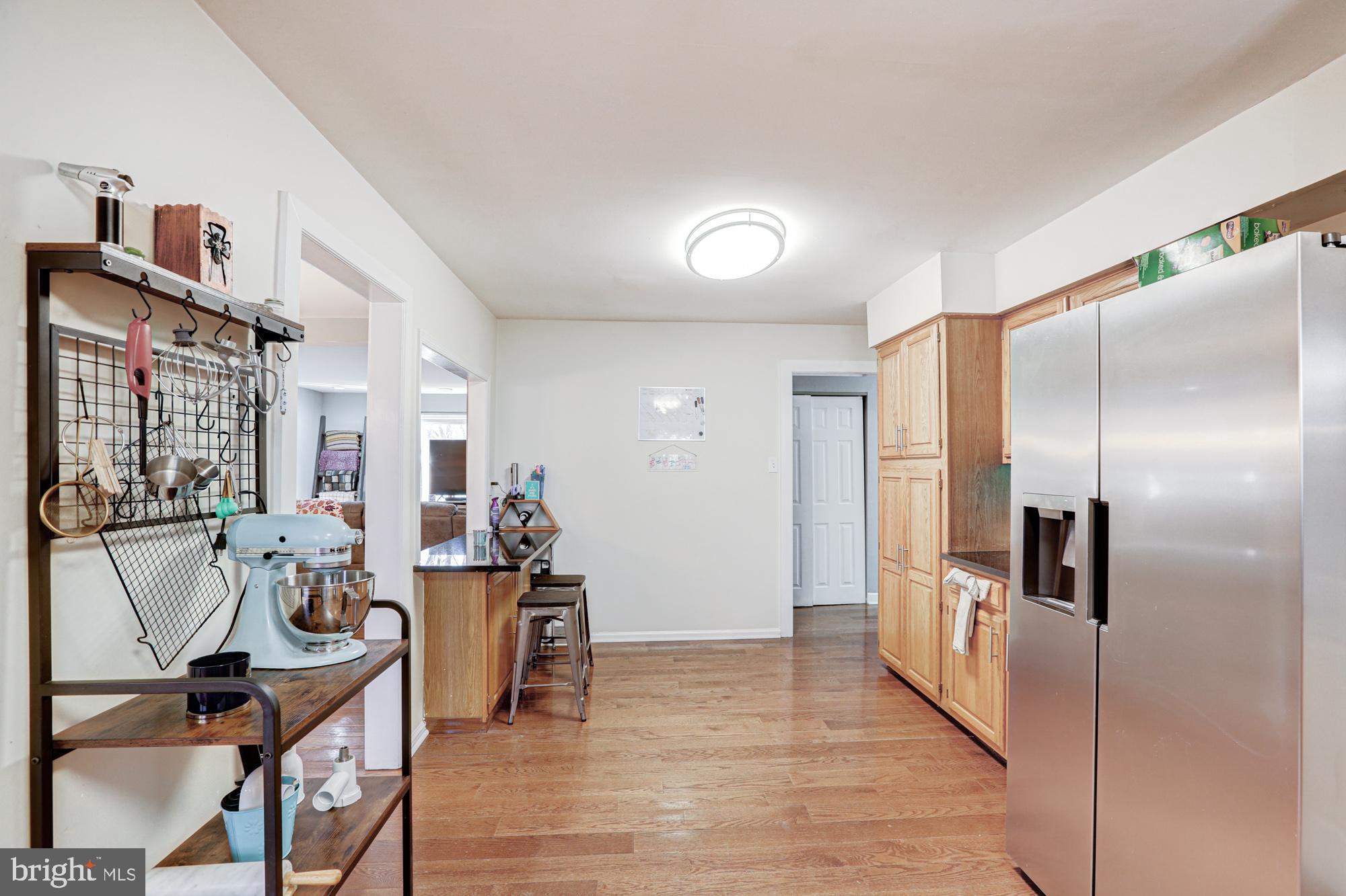 15 Evergreen Drive Newark, DE 19702 - Photo 31 of 85 a kitchen with stainless steel appliances kitchen island granite countertop a refrigerator a stove and a dining table with wooden floor