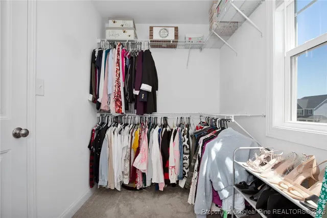 a view of walk in closet with clothes