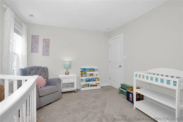 a living room with a baby crib furniture and a window