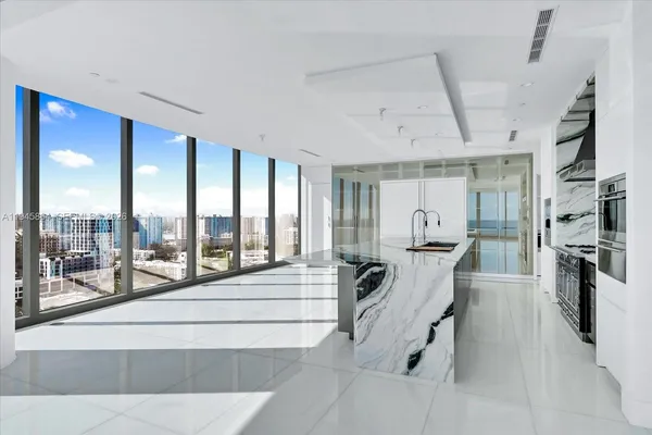 a view of a living room and kitchen floor to ceiling windows