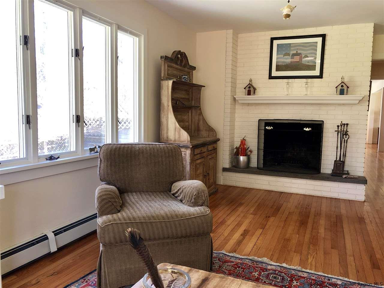 52 Buck Road Stone Ridge, NY 12484 - Photo 16 of 35 a living room with furniture a fireplace and a large window